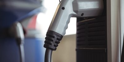 Close-up of car charger at electric vehicle charging station